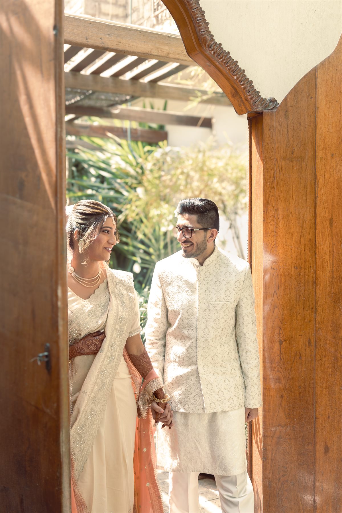 Bride and groom smiling together in a wooden doorway