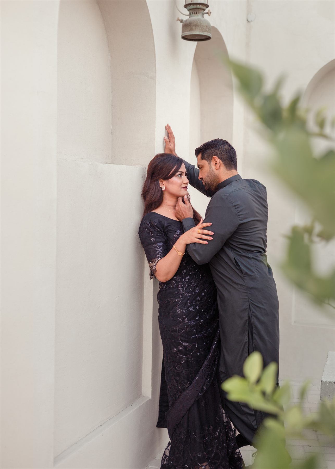 Couple posing together in an arched walkway
